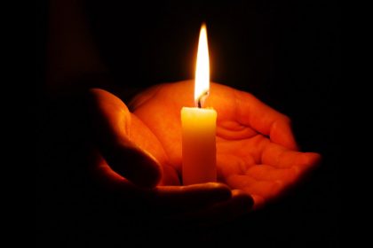 Woman Holding Candle In The Darkness