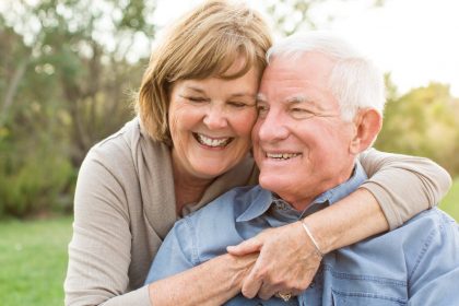 Happy Older Couple In a Meadow During the Day