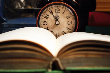 Old Retro Alarm Clock and Old Book, Open