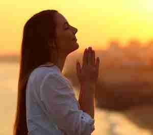 Woman Praying At Sunset