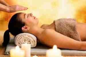 Relaxed Woman Receiving Reiki Treatment At The Spa