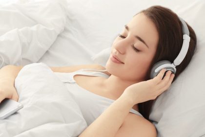 Woman Sleeping Peacefully In Bed With Headphones