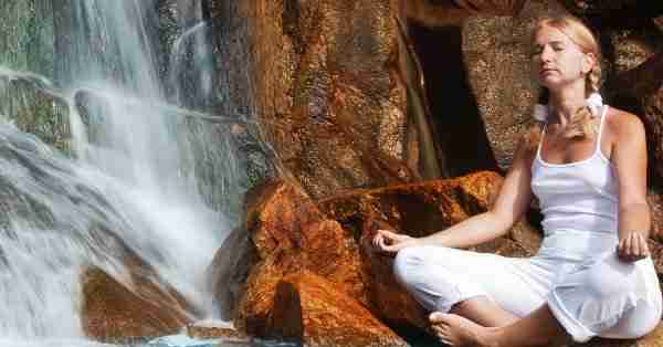 Woman Meditating By A Waterfall