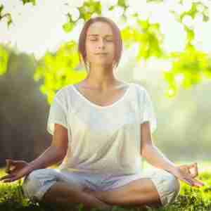 Woman Meditating In Park