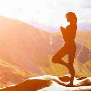 Woman Doing Yoga at Sunset on a Mountaintop