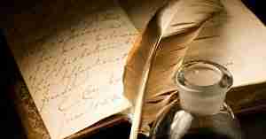 Journal and Old Feathered Quill Pen With A Candle